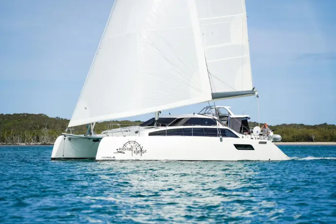 a white sailboat sailing on a body of water